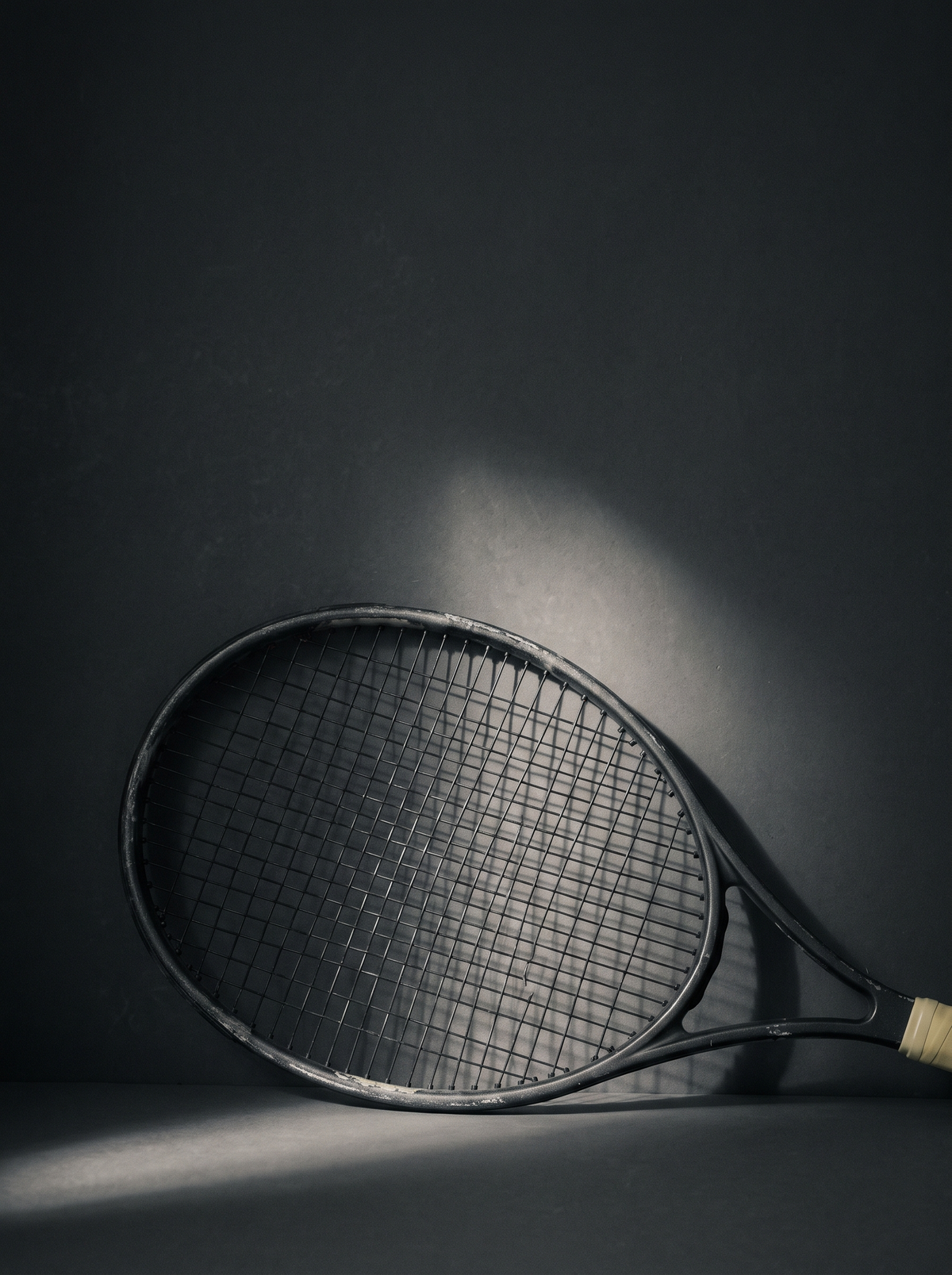 Raket tenis disorot lampu keras dengan latar gelap